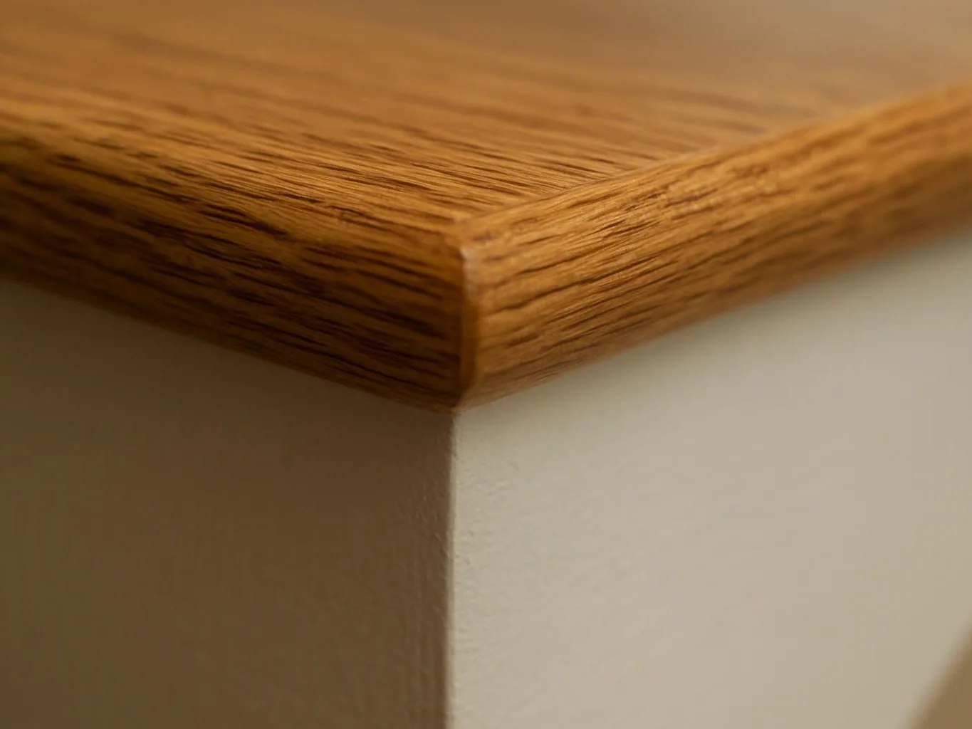 Close-up of a wooden shelf corner against a plain light wall